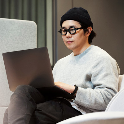 A man sitting with a laptop in an office environment